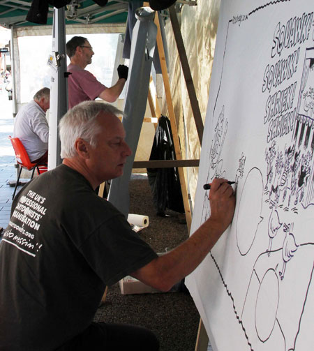 Pete Dredge works on a big board cartoon at Southport. You can see Bill Stott and Rich Skipworth hard at work too