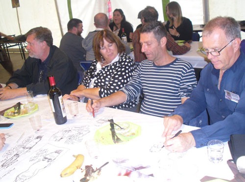 Jean Gouders, in the striped  shirt, and John Landers, in the traditional "defacing" of tablecloths